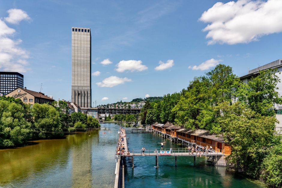 Swimmers enjoying a sunny day by a city river